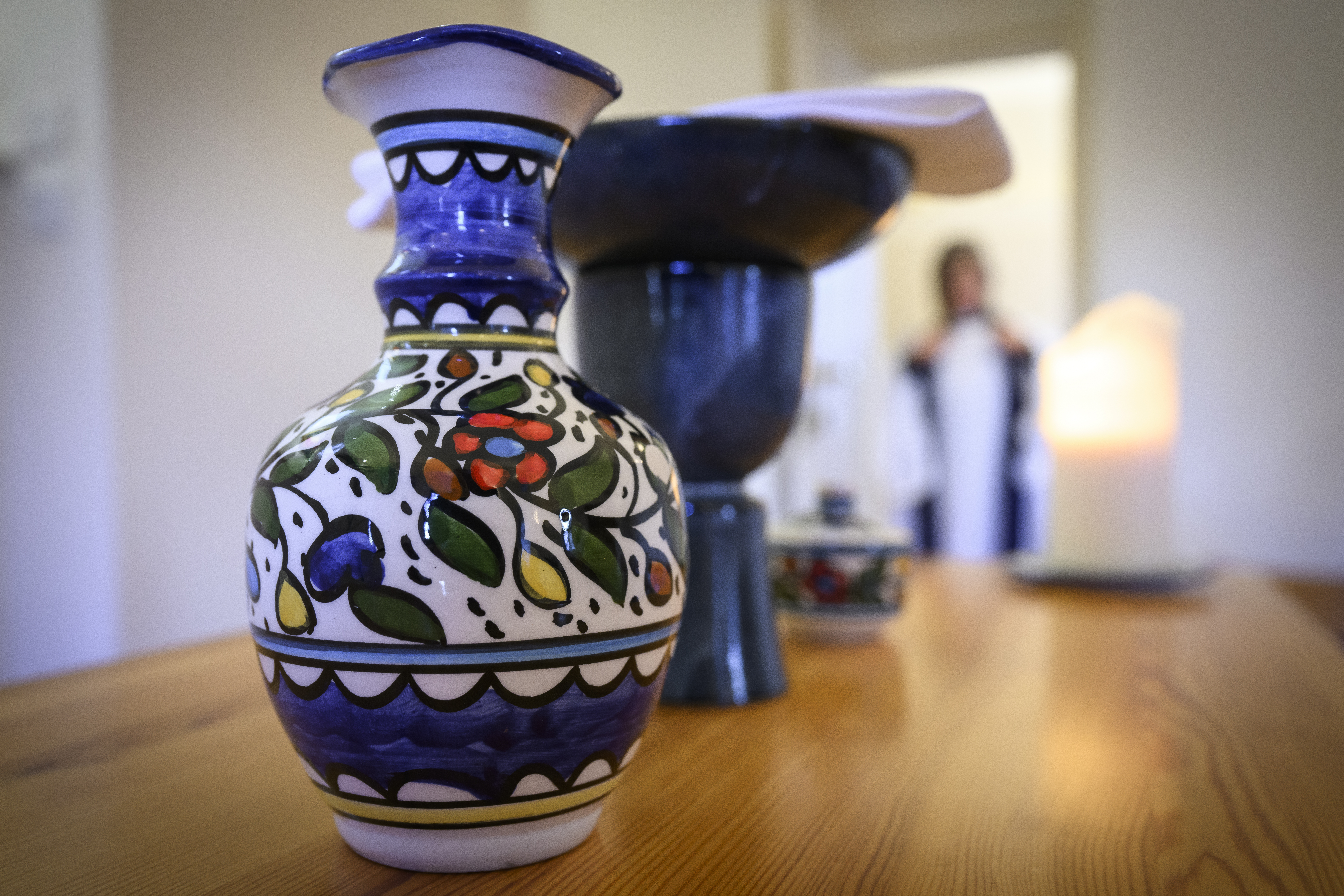 En färggrann keramikvas står på ett bord.
