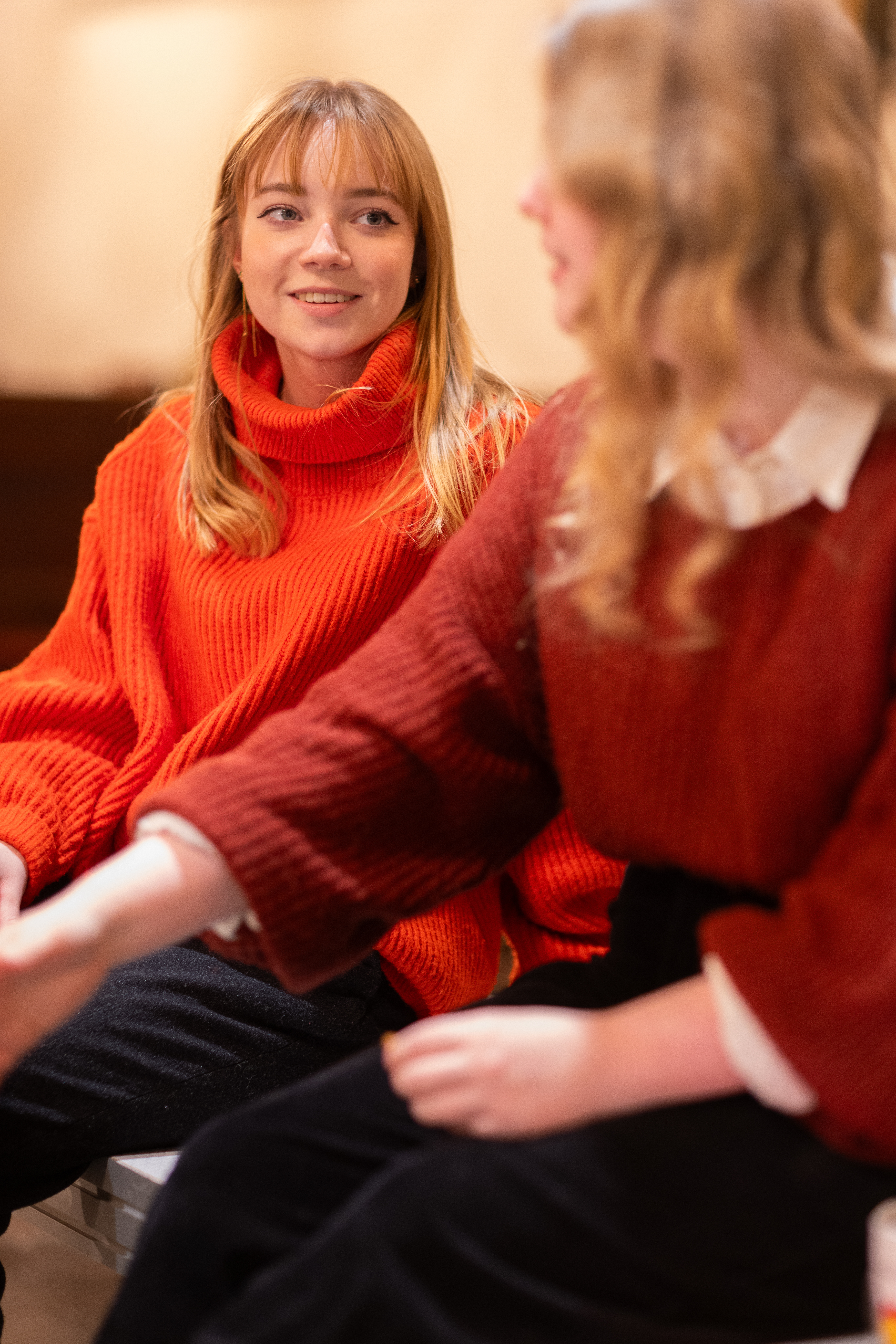 Två unga kvinnor sitter och samtalar.