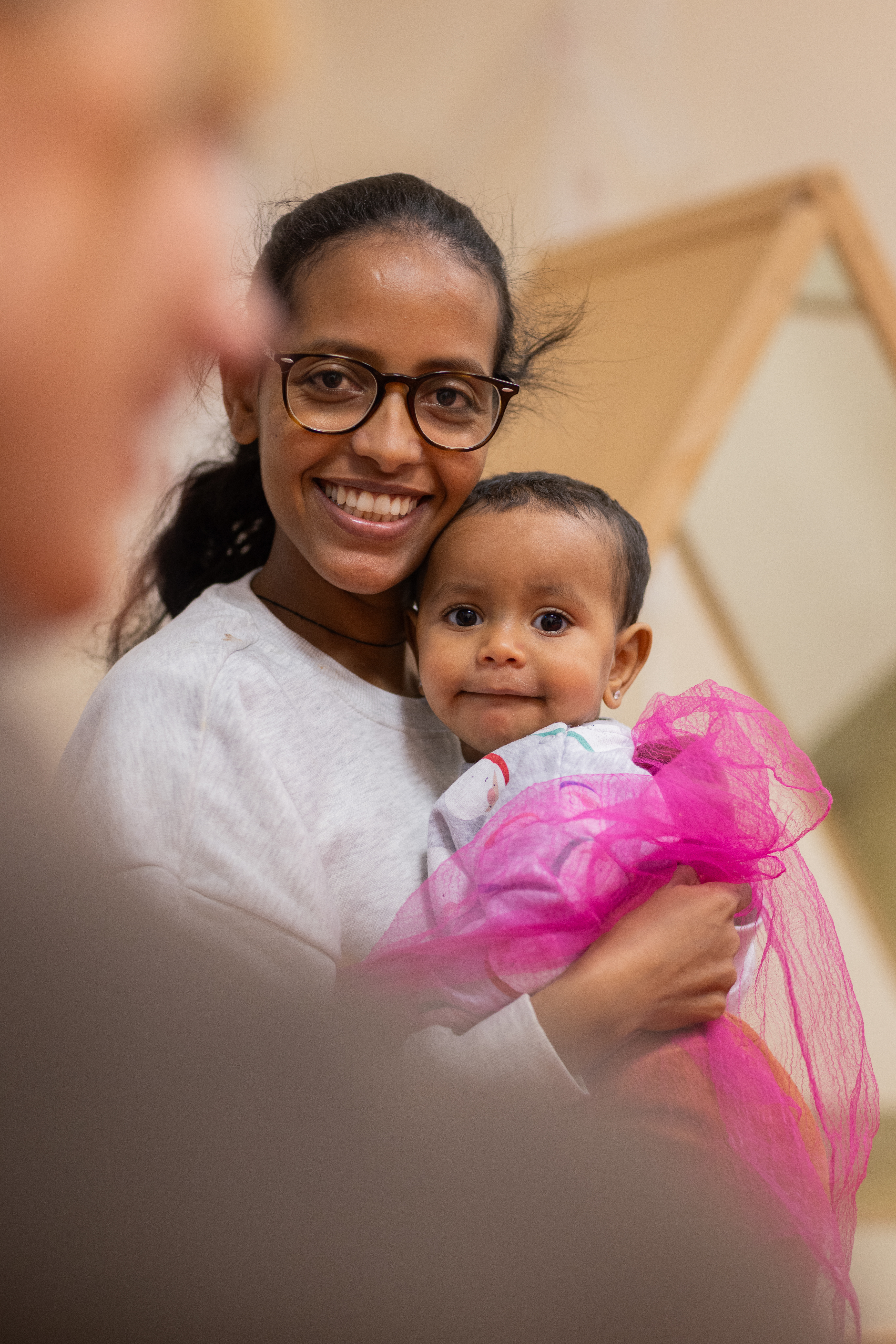 En mamma sitter med en bebis i famnen.