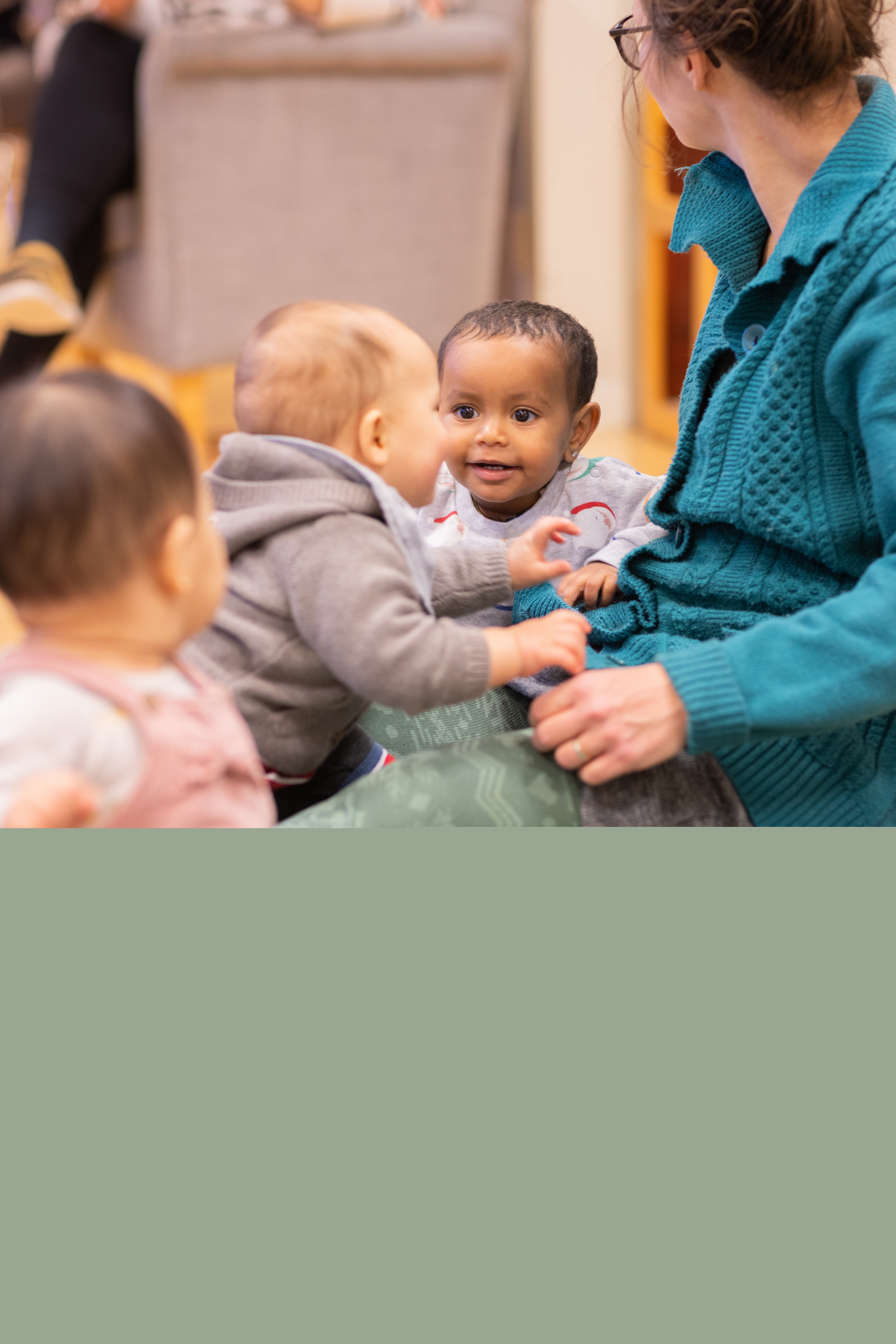 Några bebisar sitter på golvet och skrattar.
