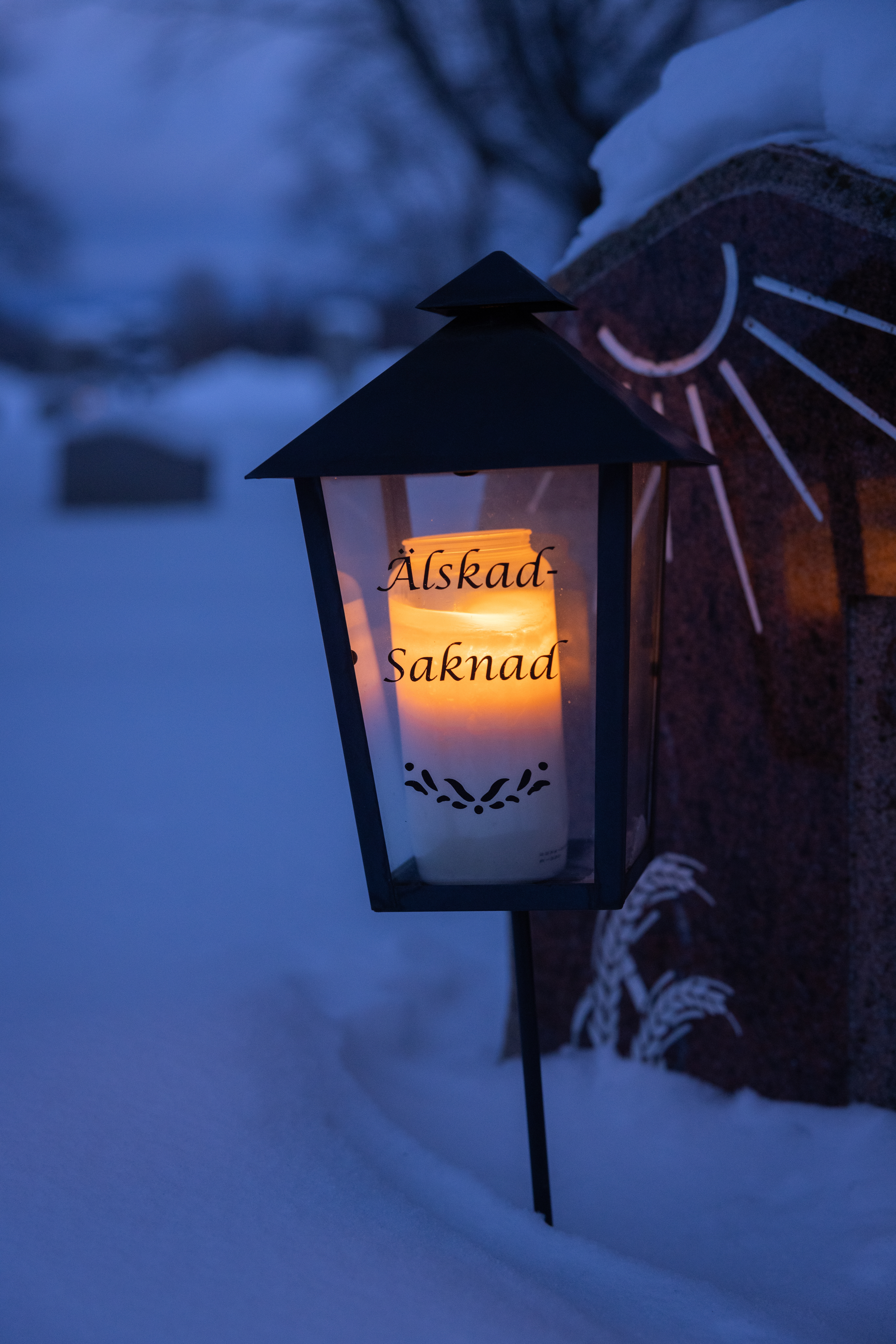 Gravljus utanför en kyrka i Hudiksvall. Det är kväll men det varma ljuset ifrån kyrkan syns ut.