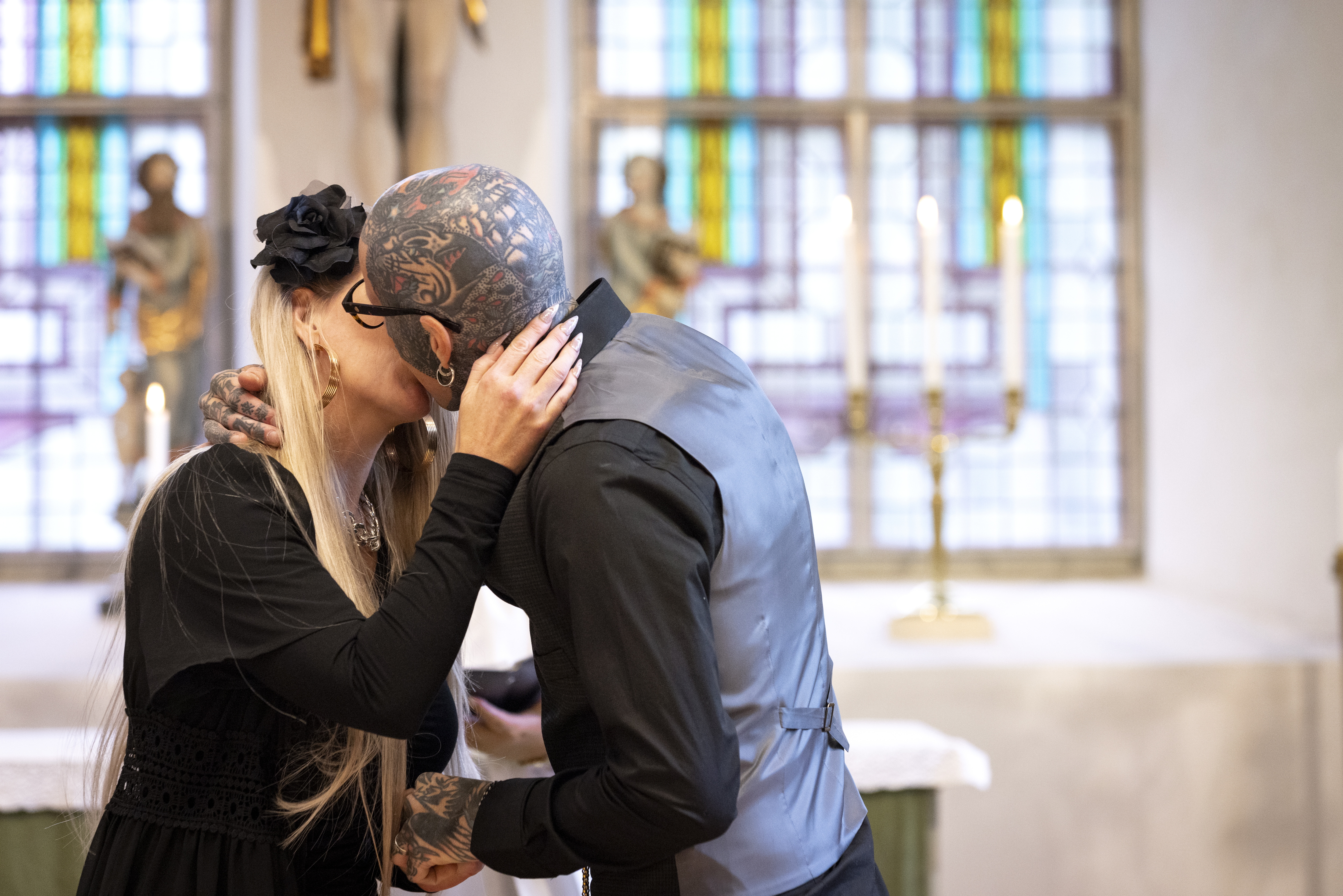 Drop-in vigsel i en kyrka. Ett brudpar kysser varandra inne i kyrkan.