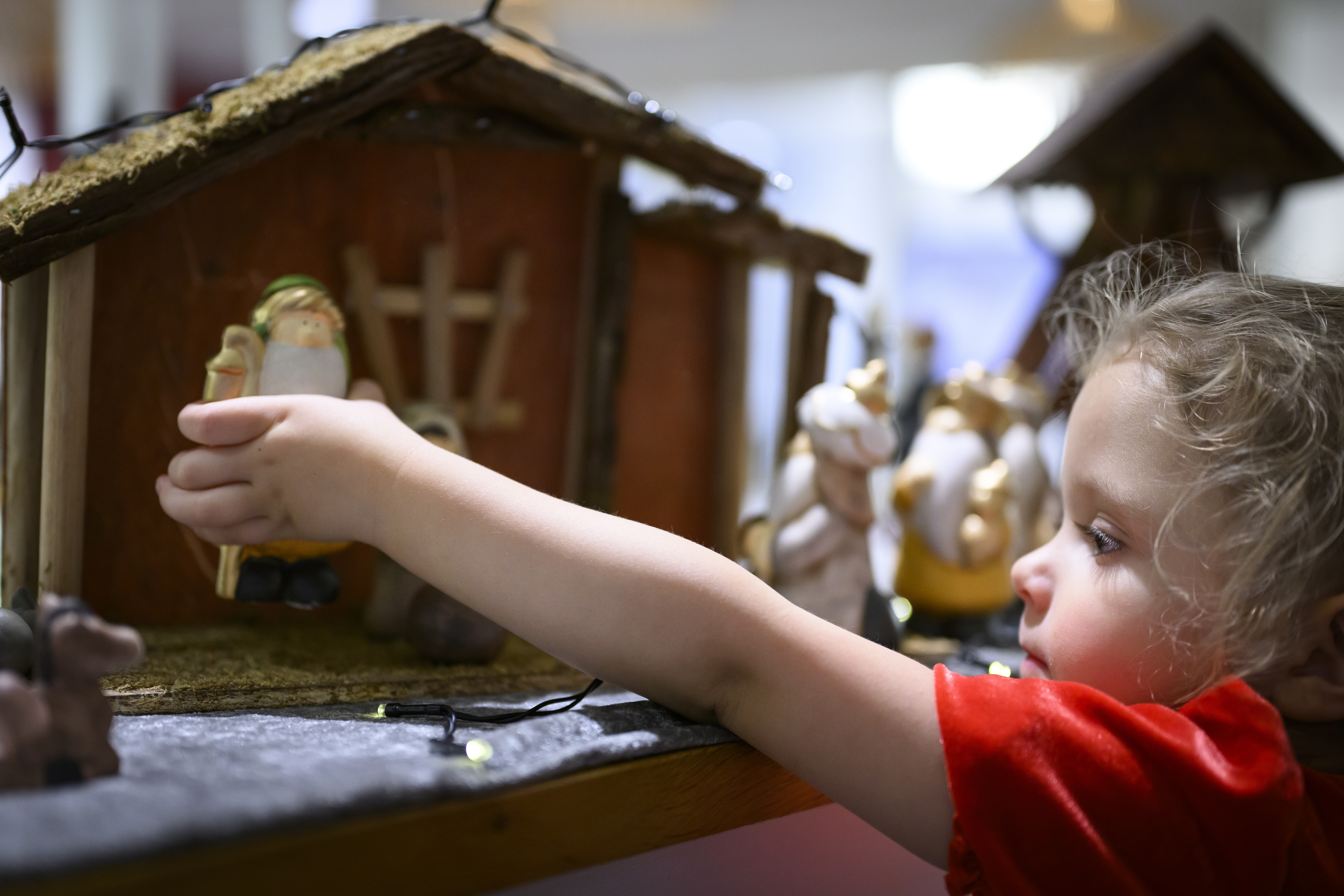 Ett litet barn leker med en julkrubba.