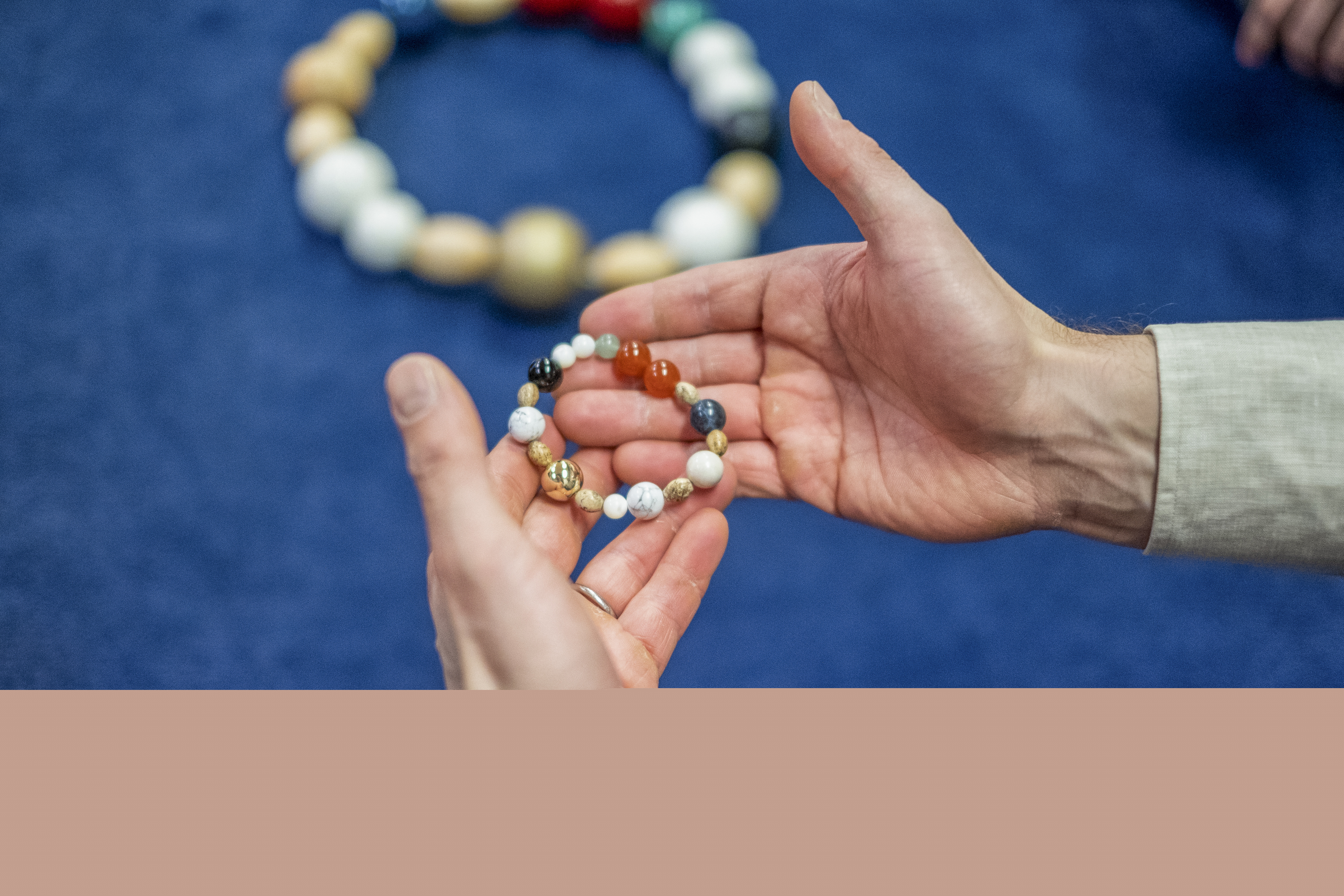 Två kupade händer håller en frälsarkrans.