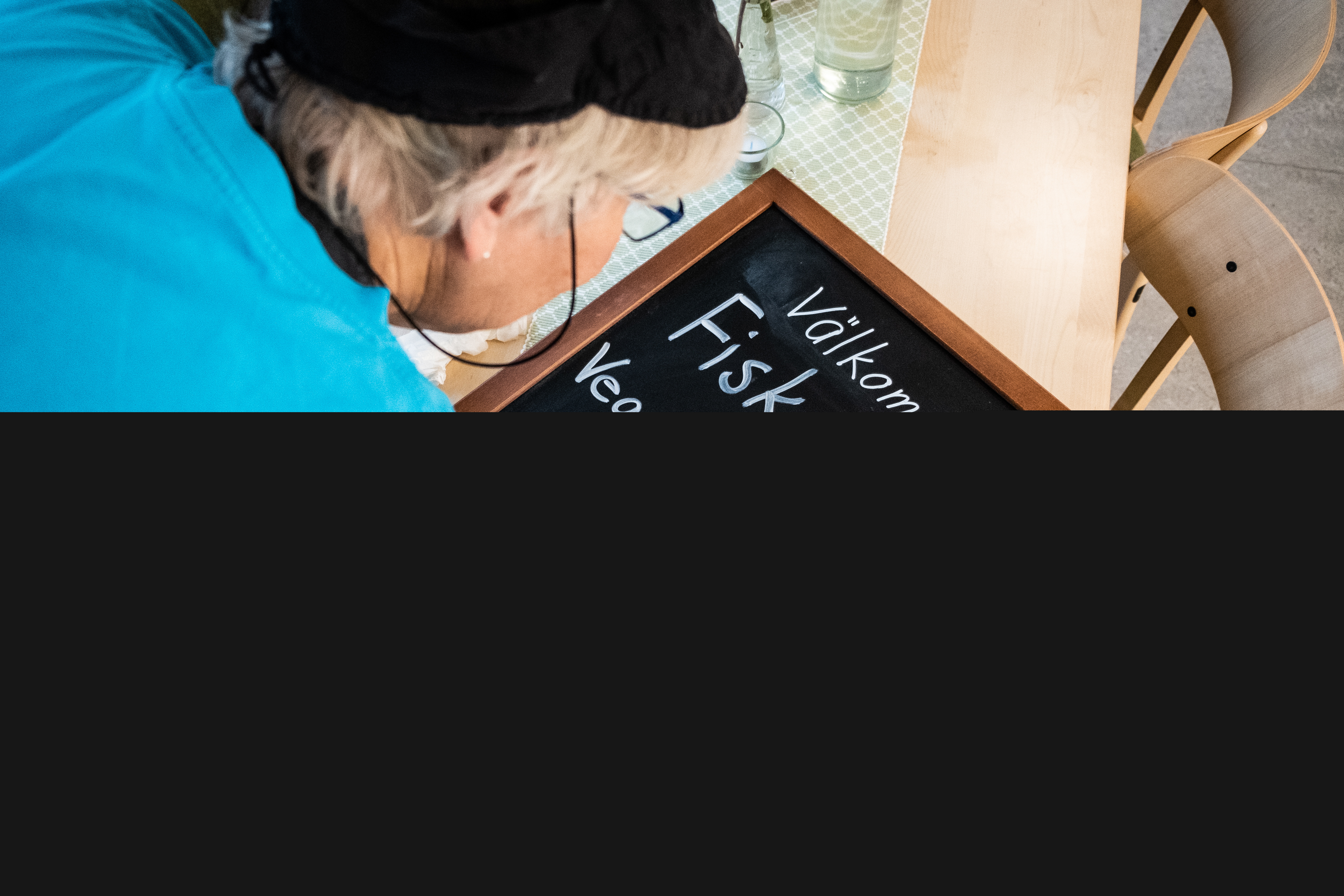 En person skriver en meny på en griffeltavla.