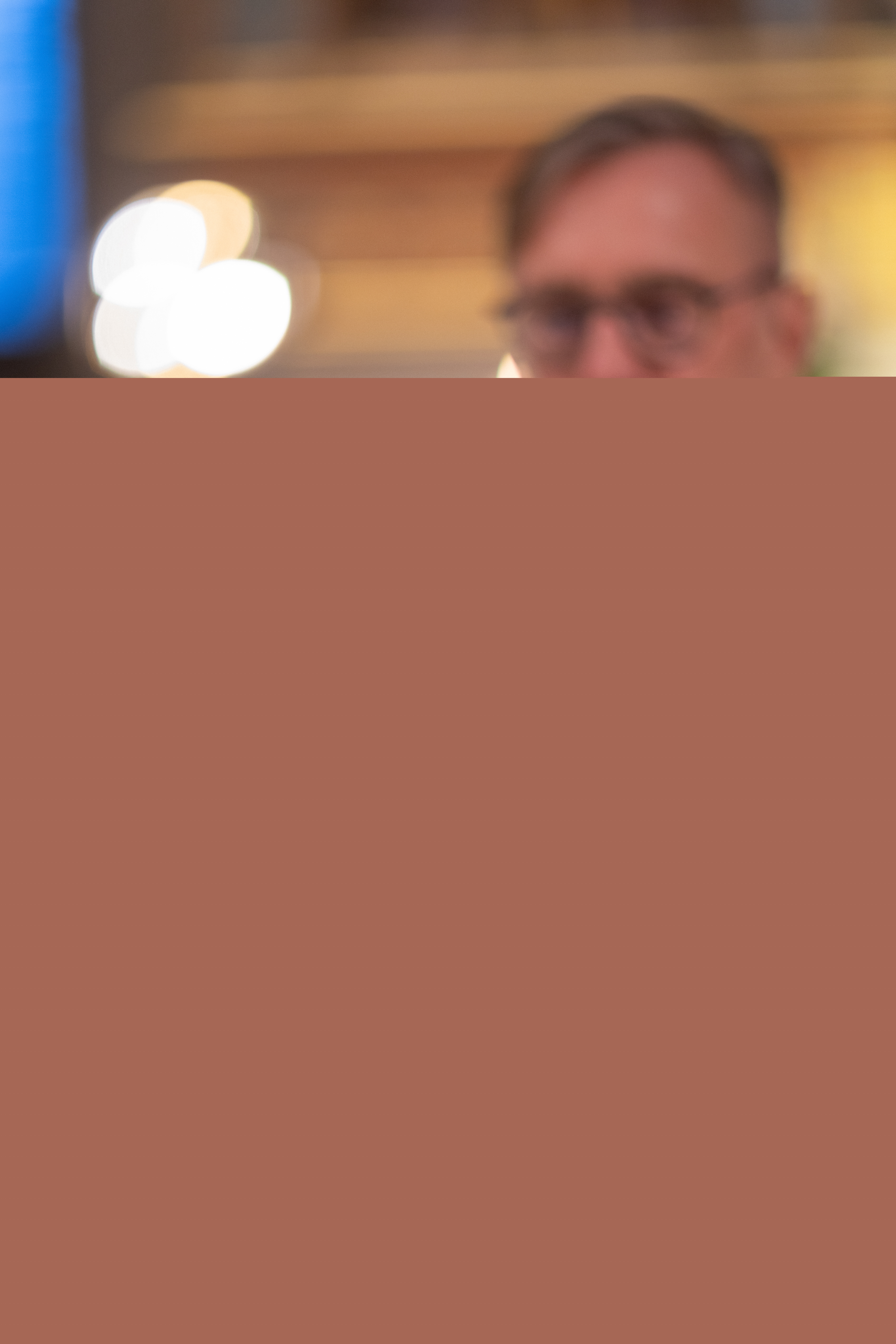 En präst lyfter upp nattvardskalken.