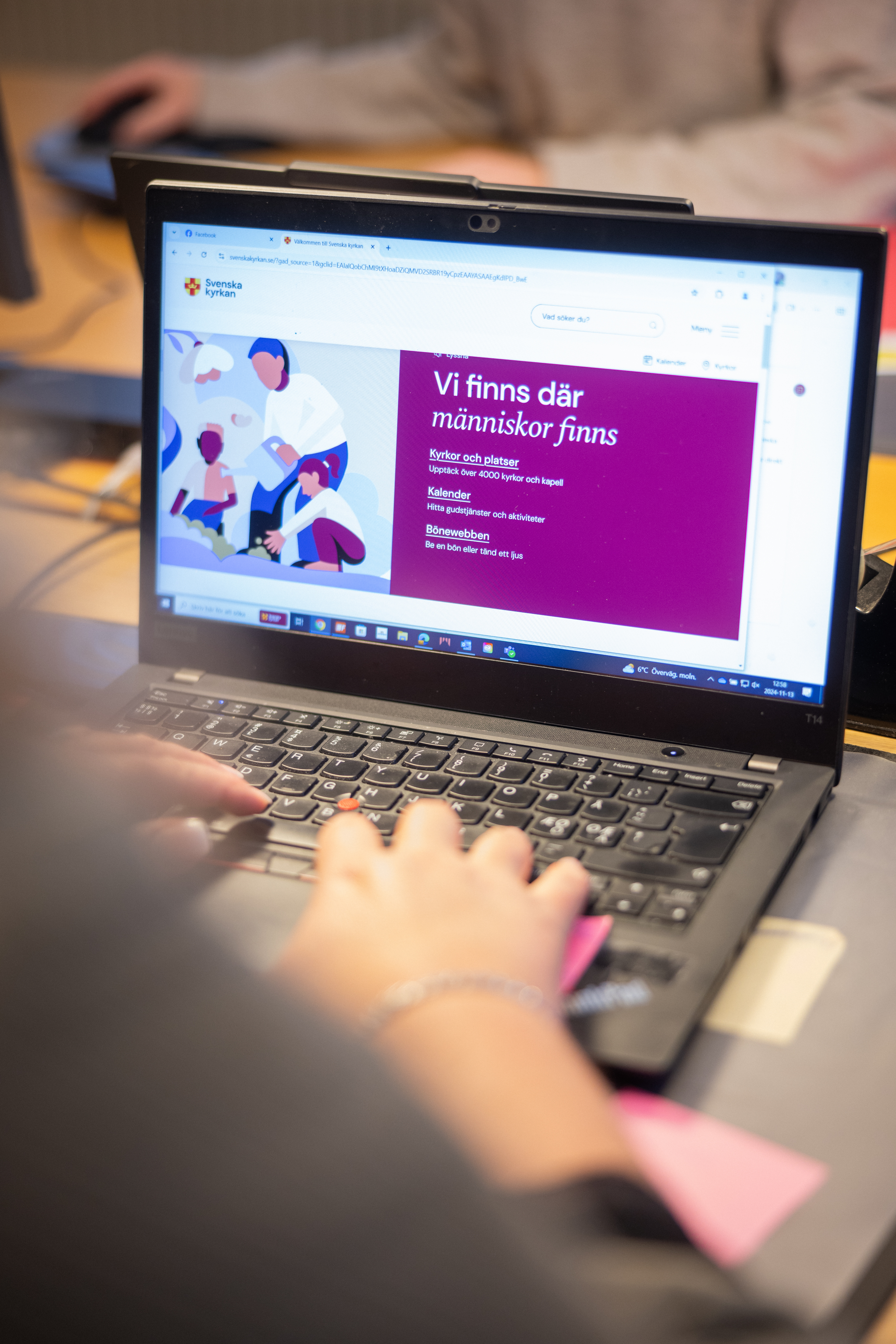 En person sitter vid en dator och skriver.