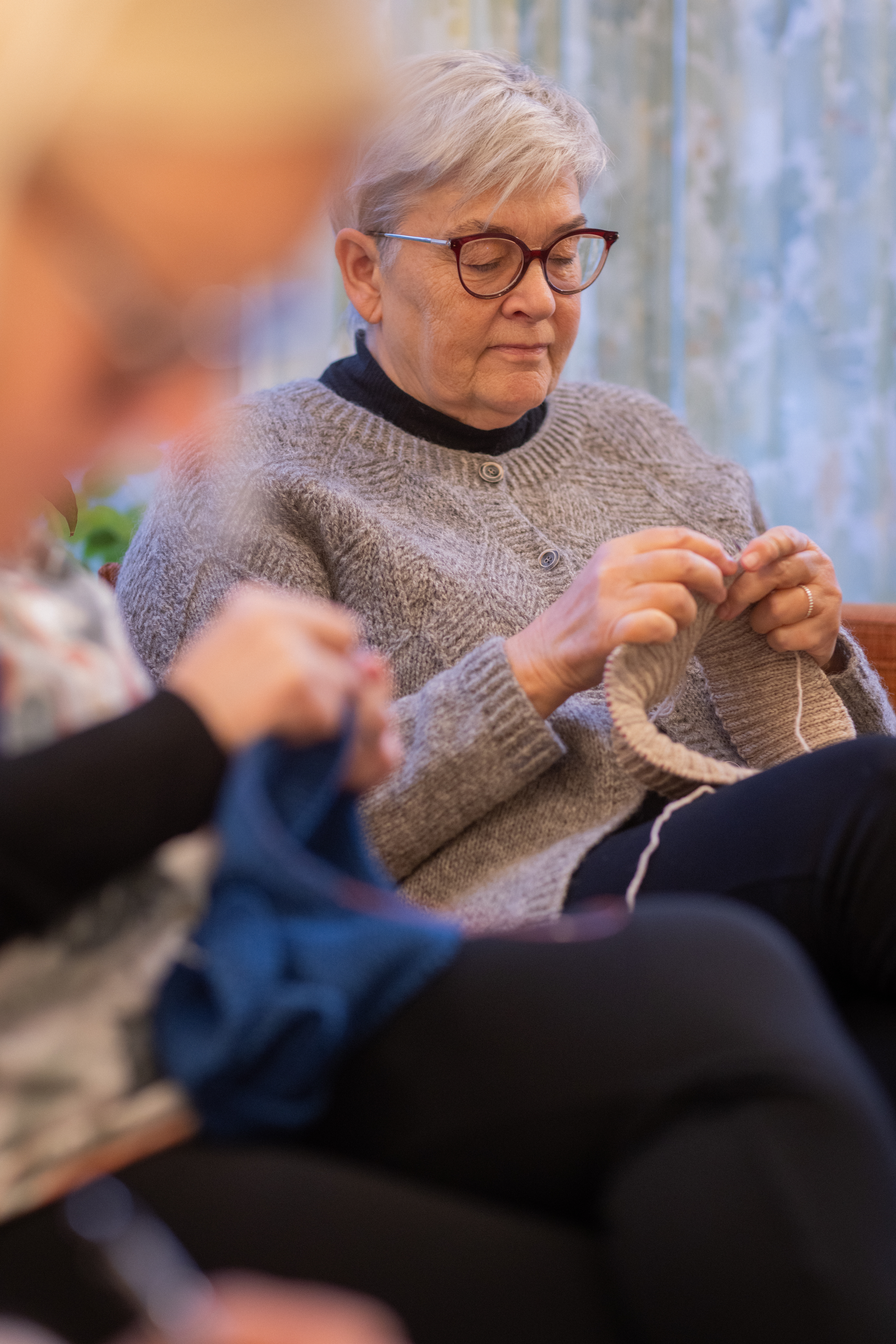 Några äldre kvinnor sitter och stickar tillsammans.