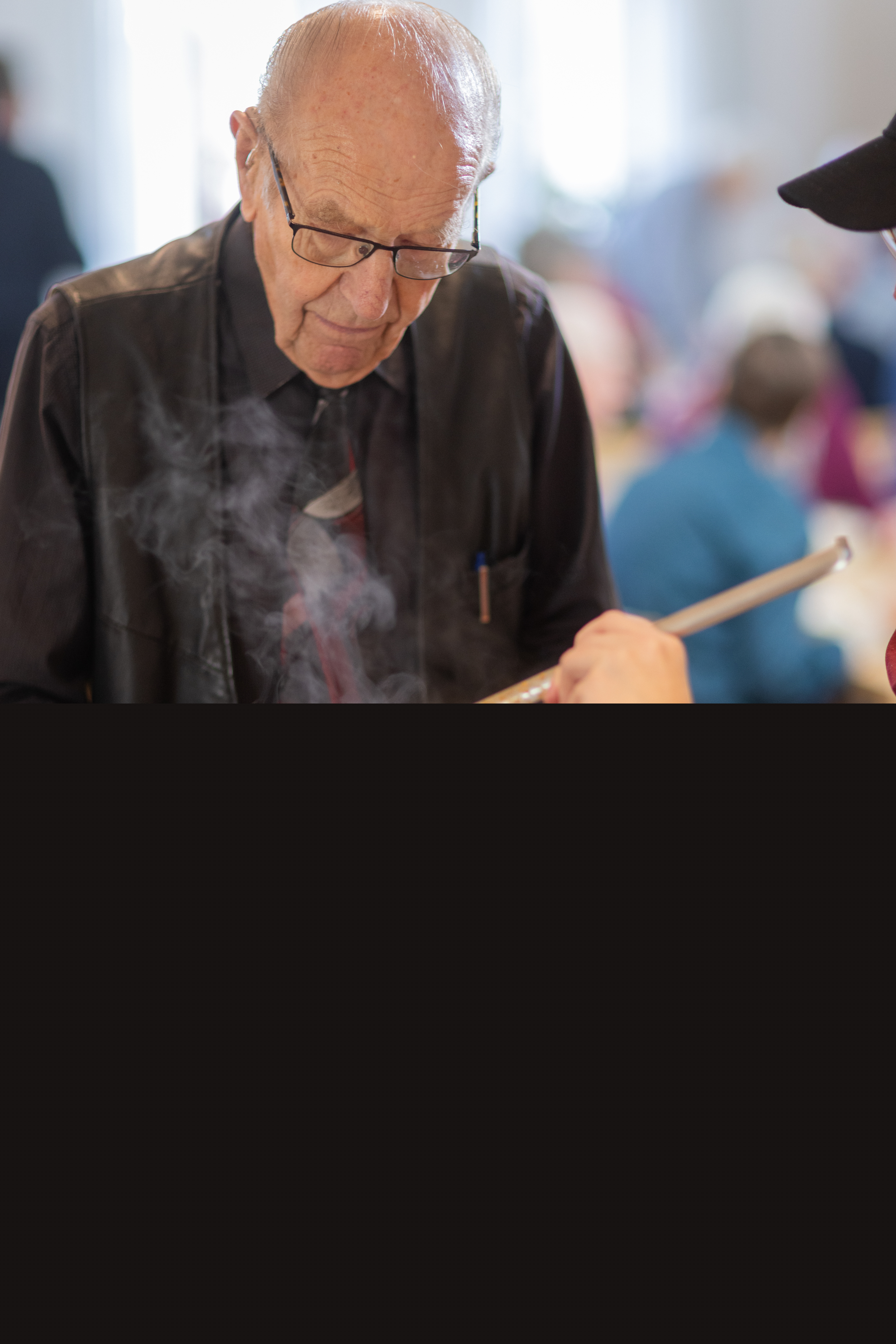 En äldre man får mat i sin tallrik i en matbespisning.