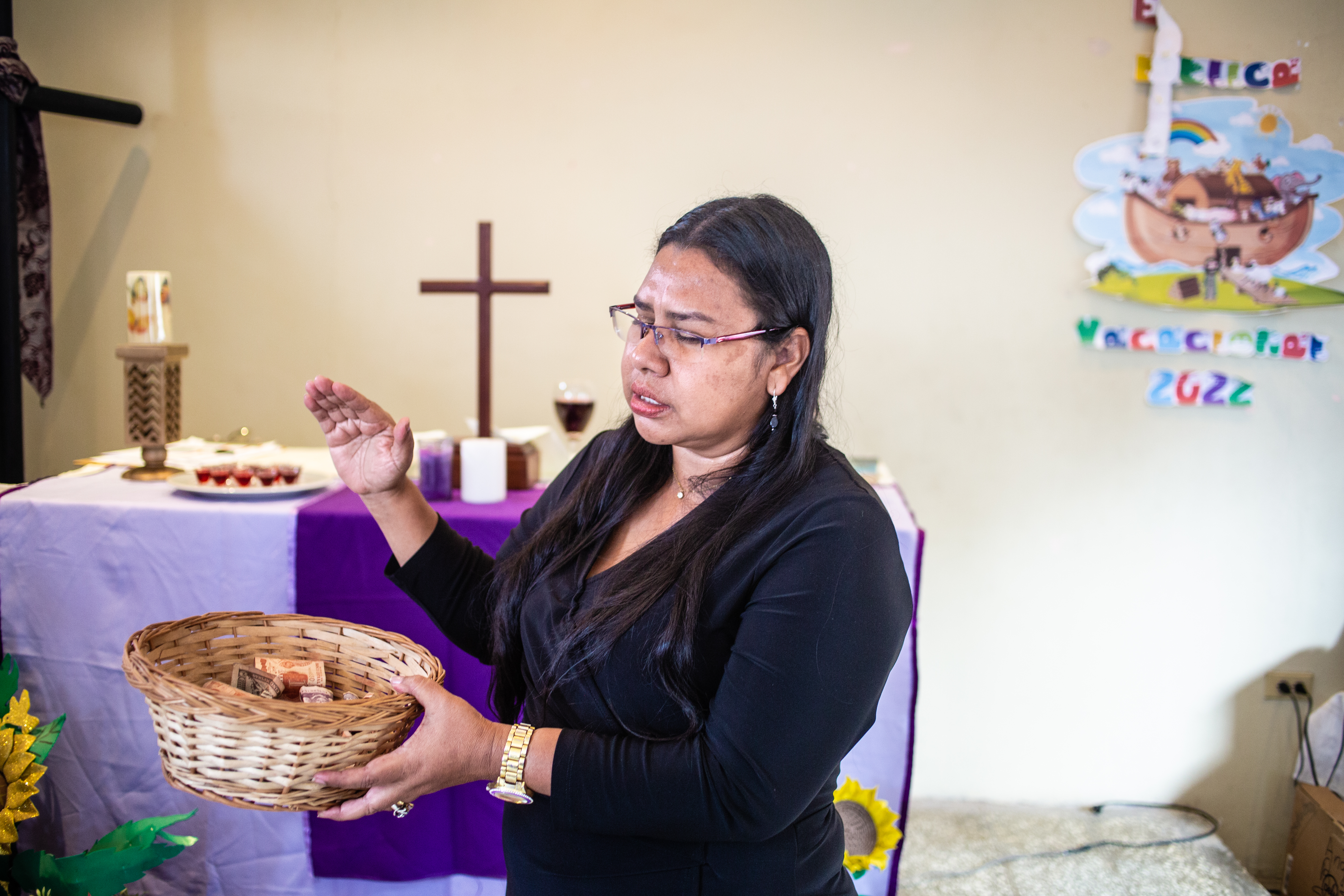 En kvinna välsignar kollekten. 