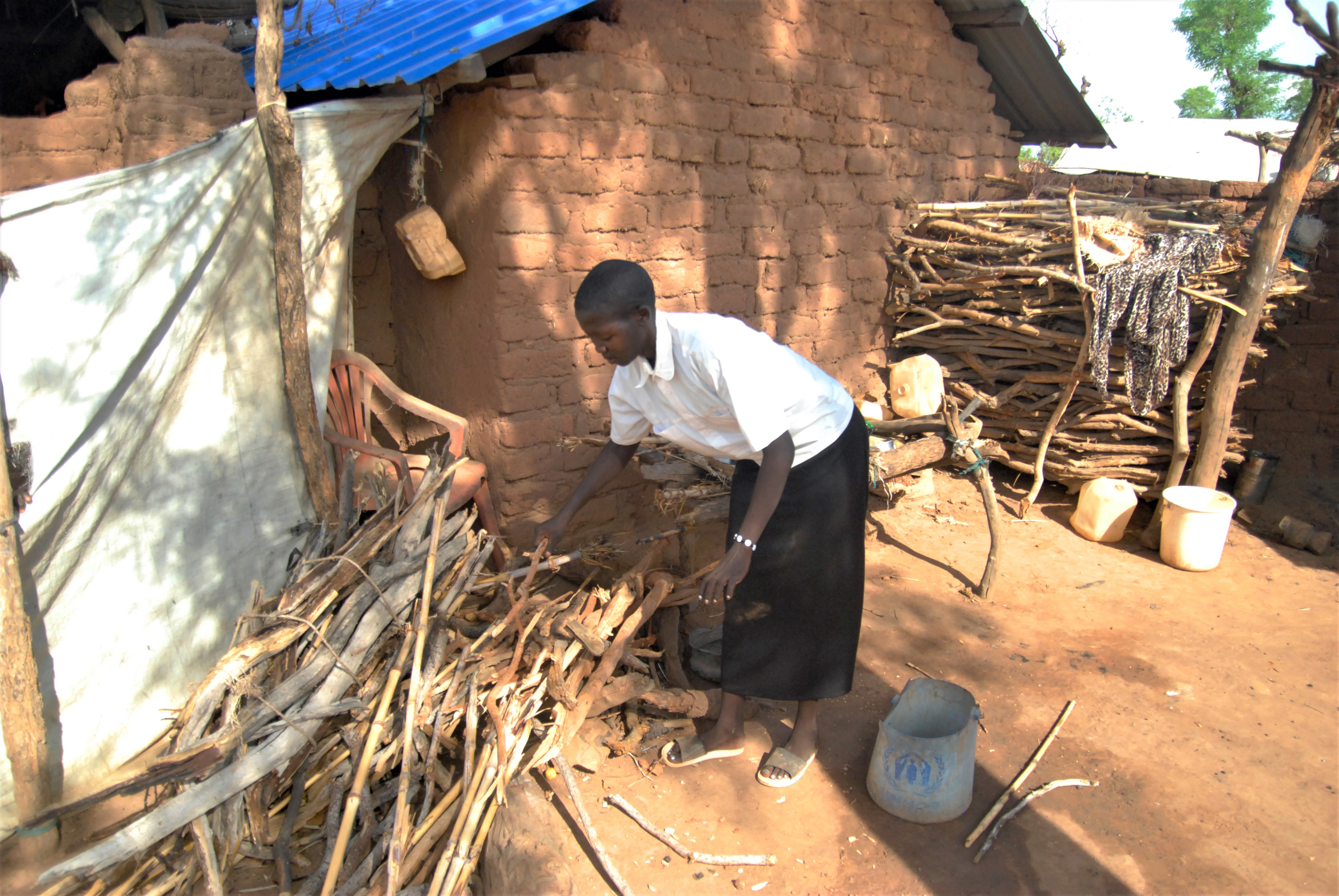 Ung kvinna samlar ved för matlagning.