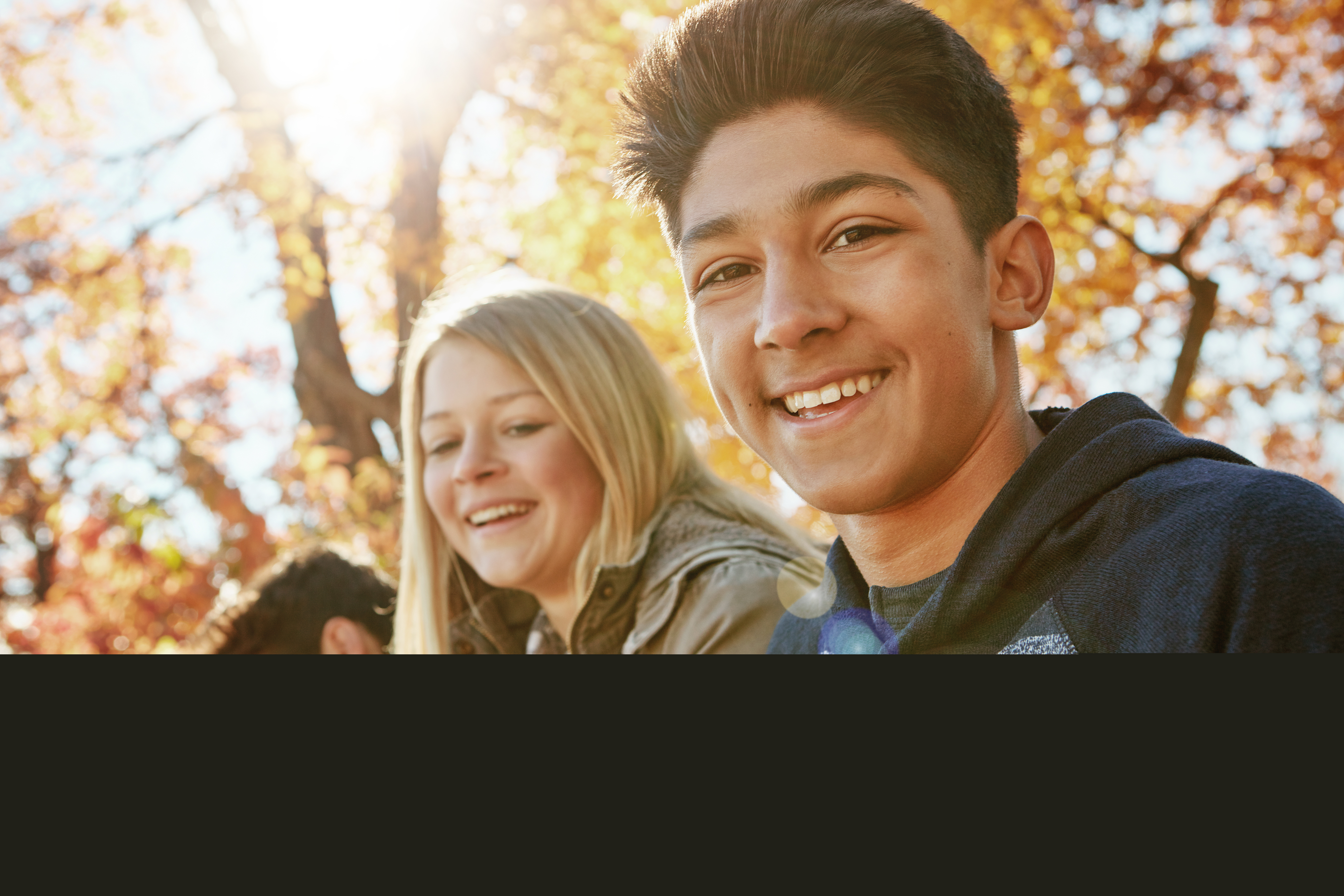 En grupp ungdomar samlade i en park på hösten.