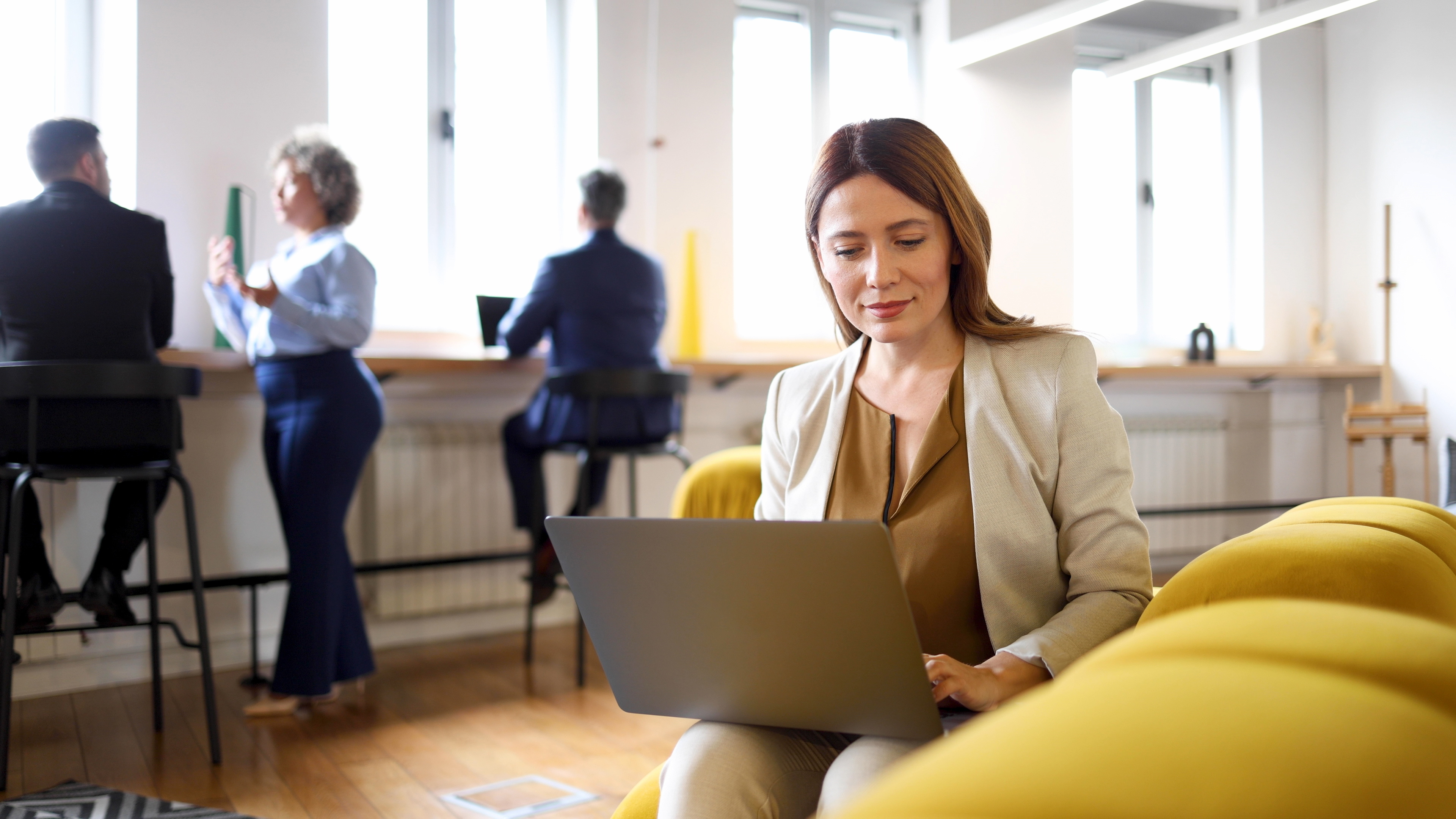 Kvinna sitter med en dator i knät.