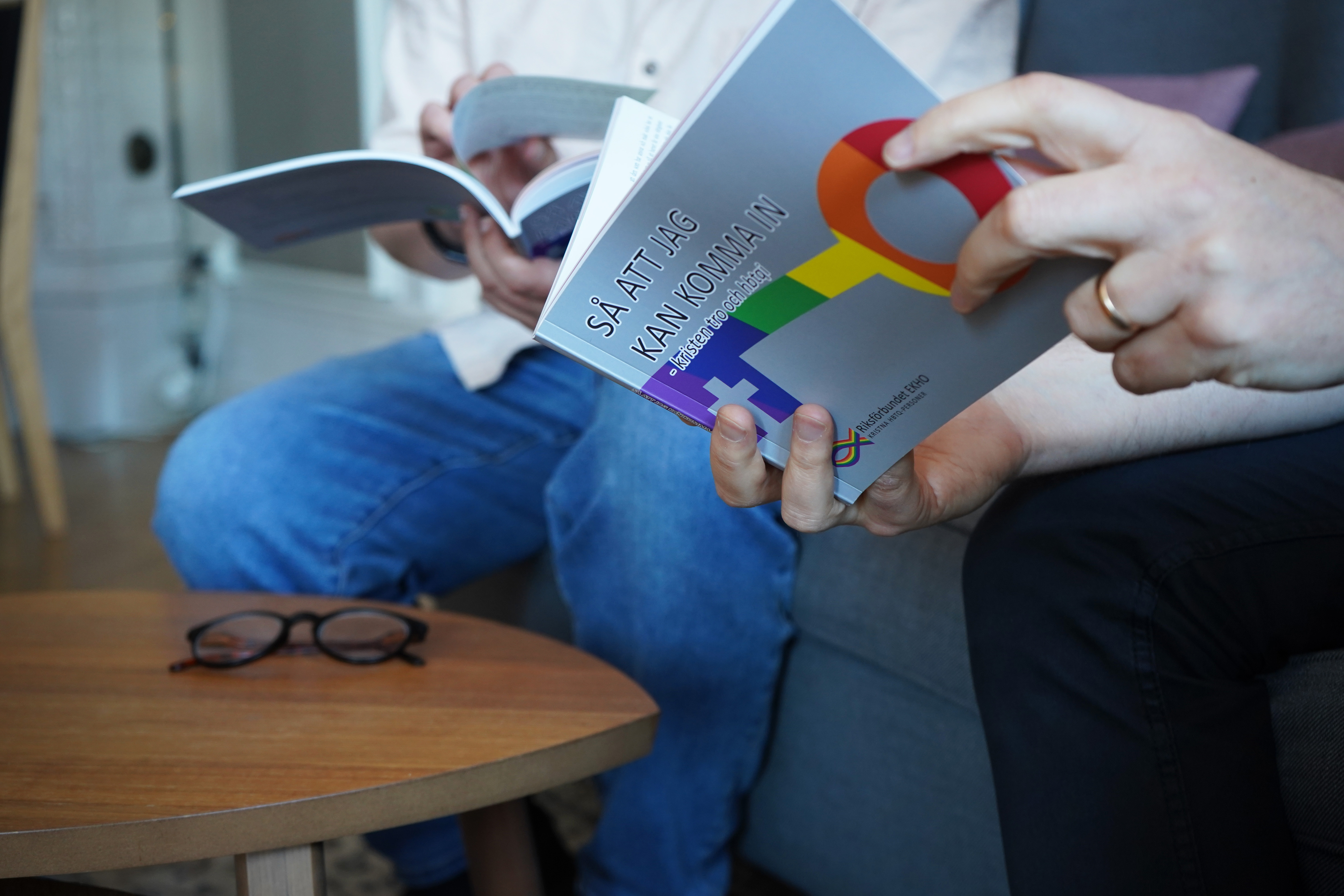 Två personer läser i och samtalar om boken "Så att jag kan komma in - kristen tro och HBTQI".