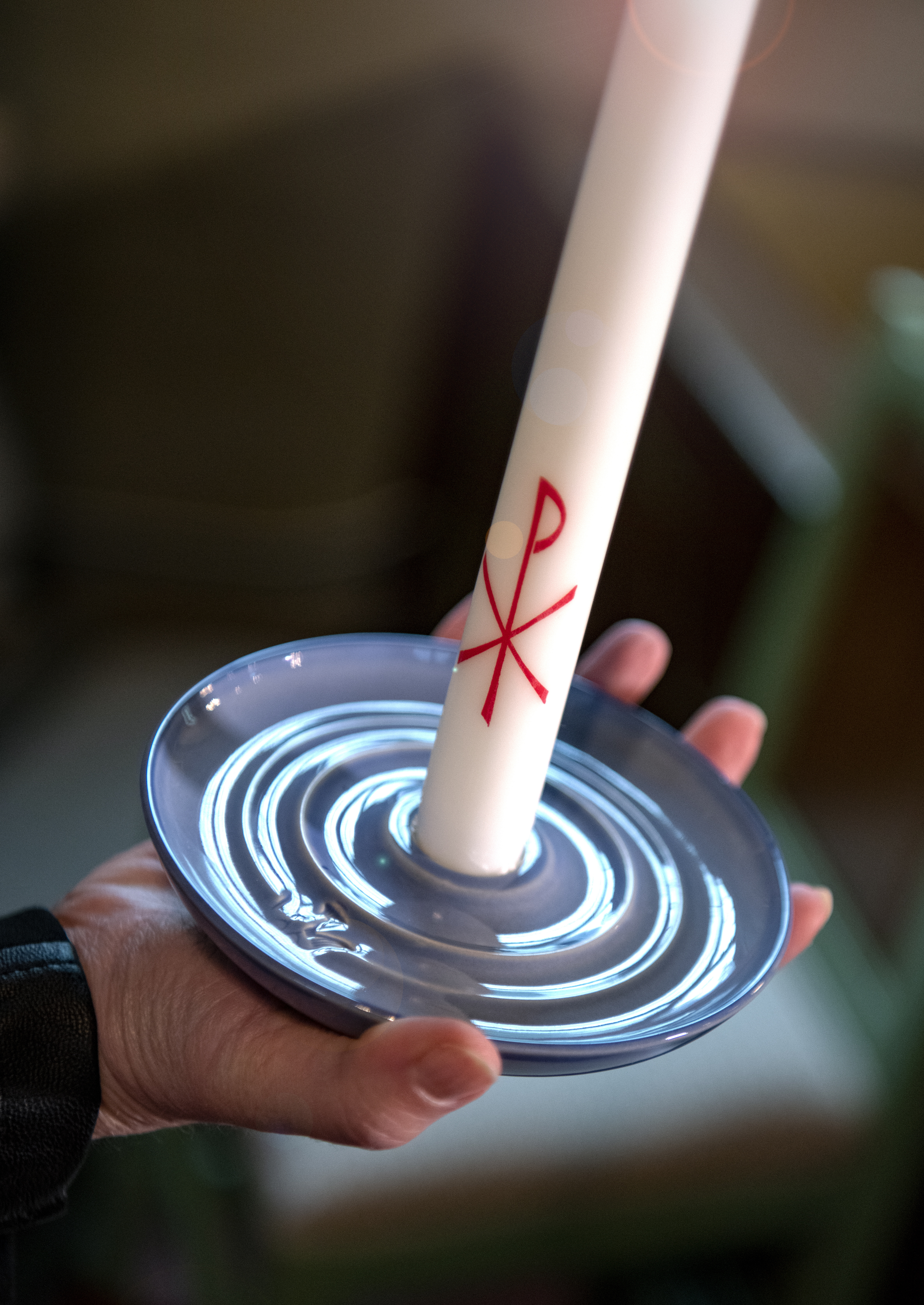 Hand håller ett dopljus.