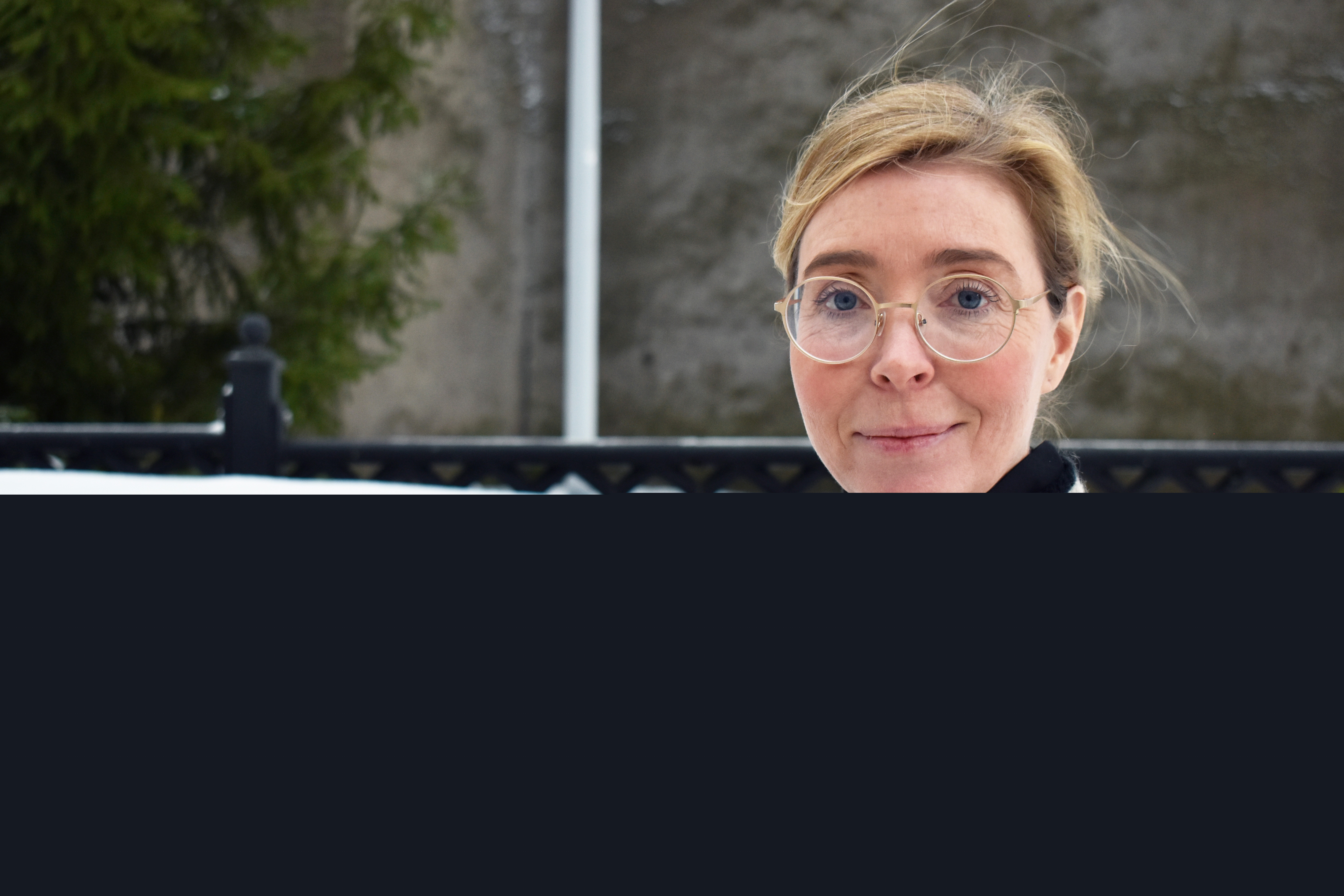 Kvinna med runda glasögon utomhus vintertid.