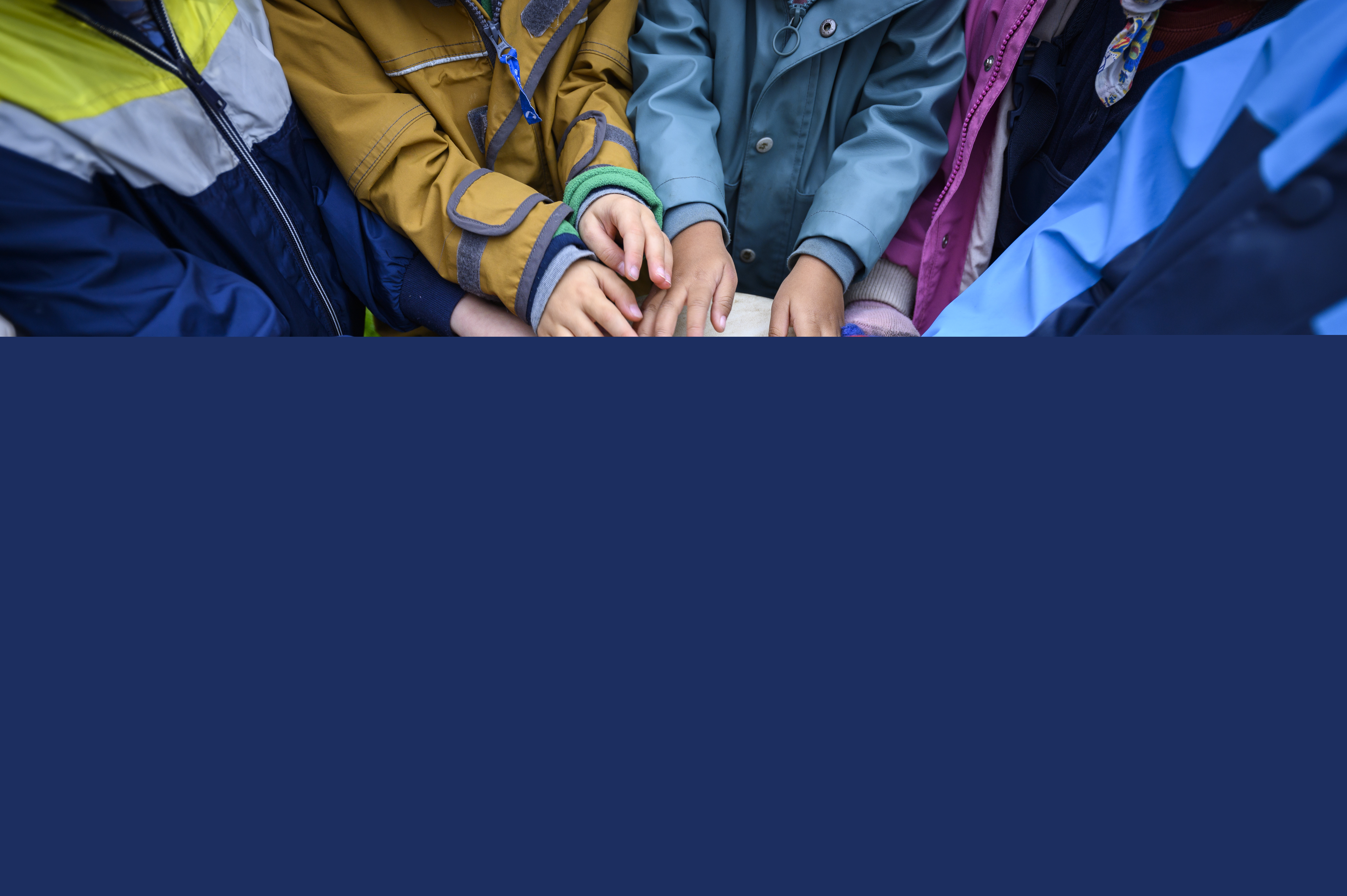 En grupp barn står utomhus och spelar på en och samma bongotrumma.