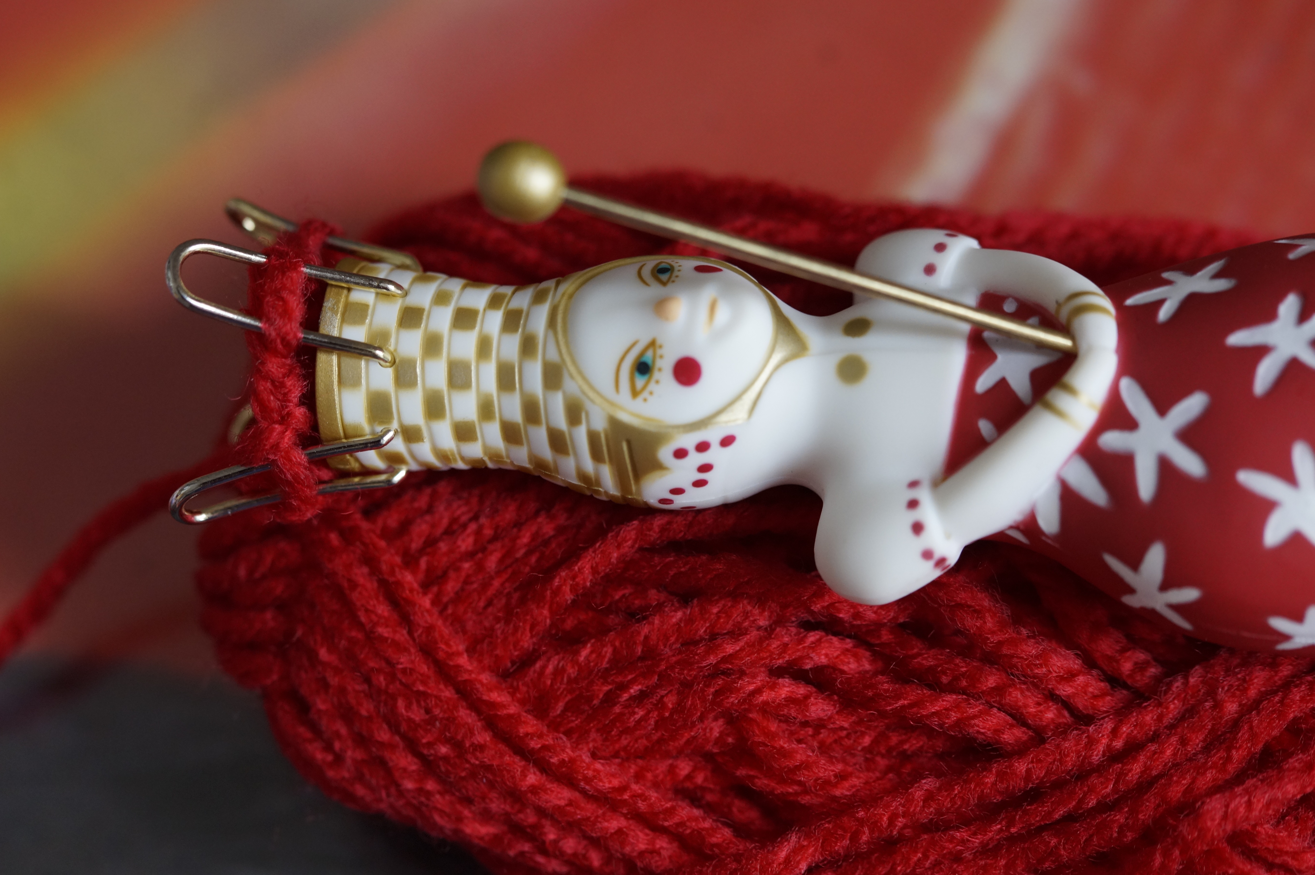 En påtdocka som ligger på ett rött garnnystan